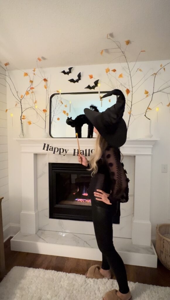 Pamela of stir and gather lighting the candles above her mantel looking extra witchy