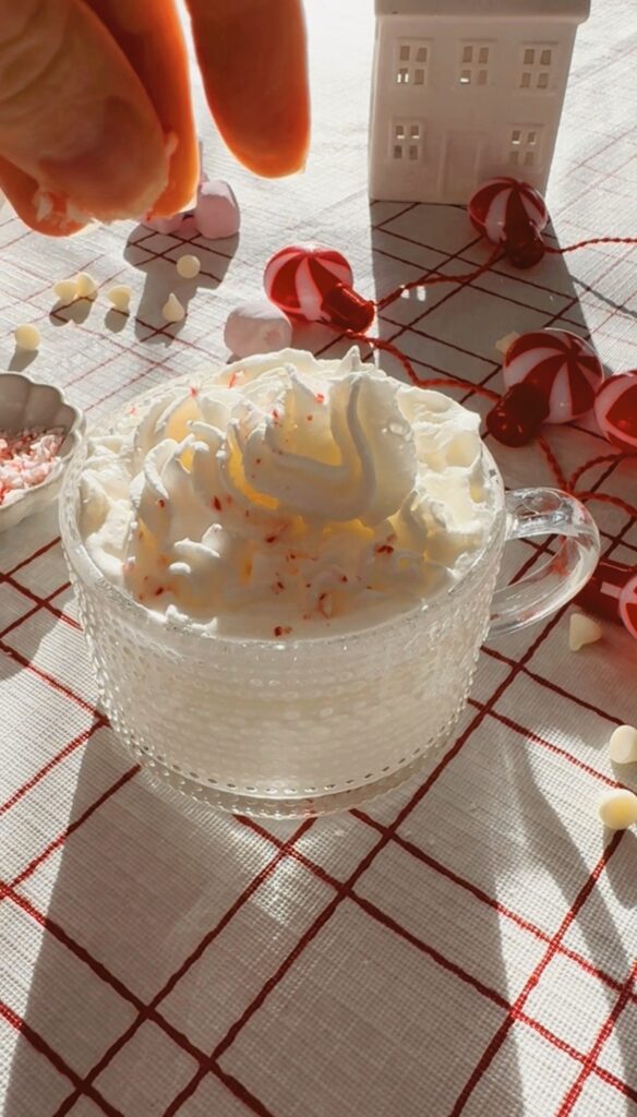 stir and gather sprinkling crushed candy canes on hot cocoa