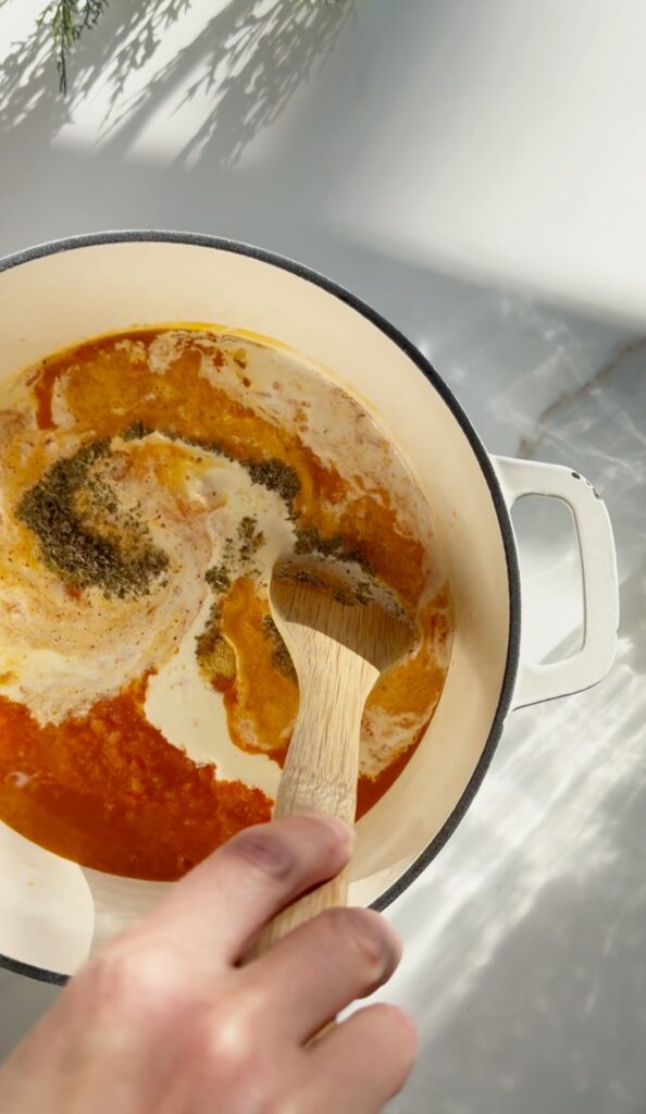 stir and gather making sheet pan tomato soup in a cast iron dutch oven
