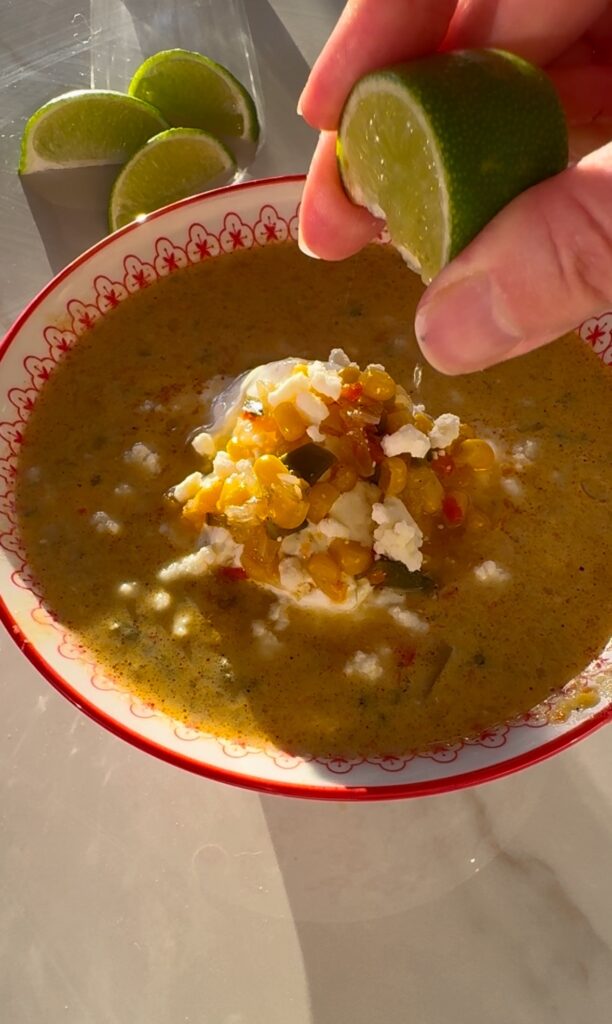 stir and gather squeezing lime over Mexican street corn soup