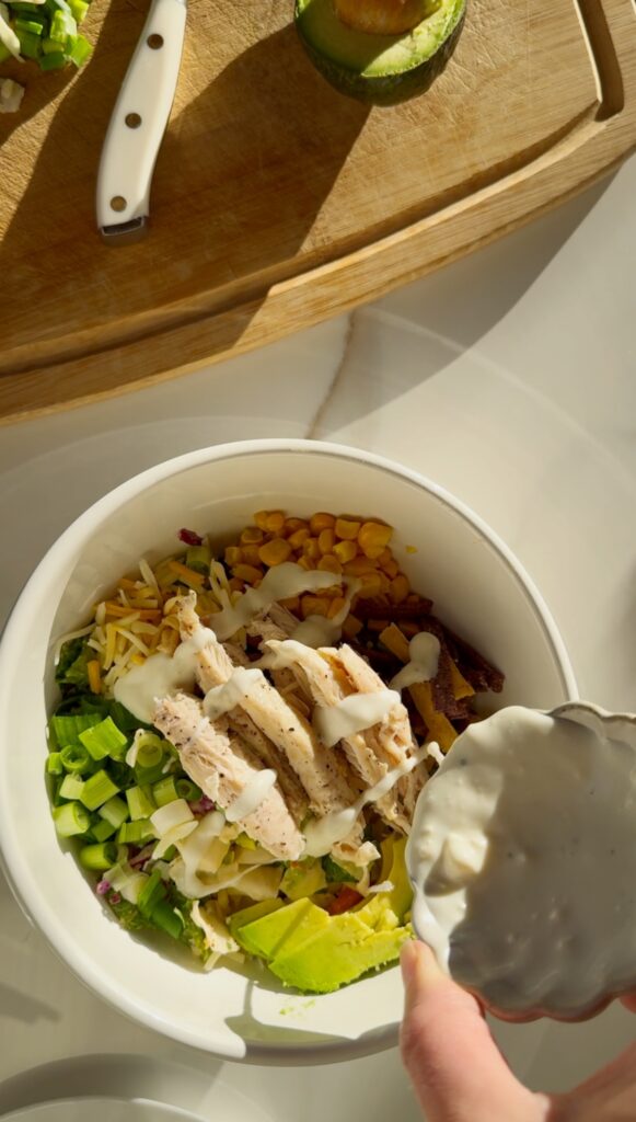 stir and gather adding blue cheese dressing to buffalo chicken salad
