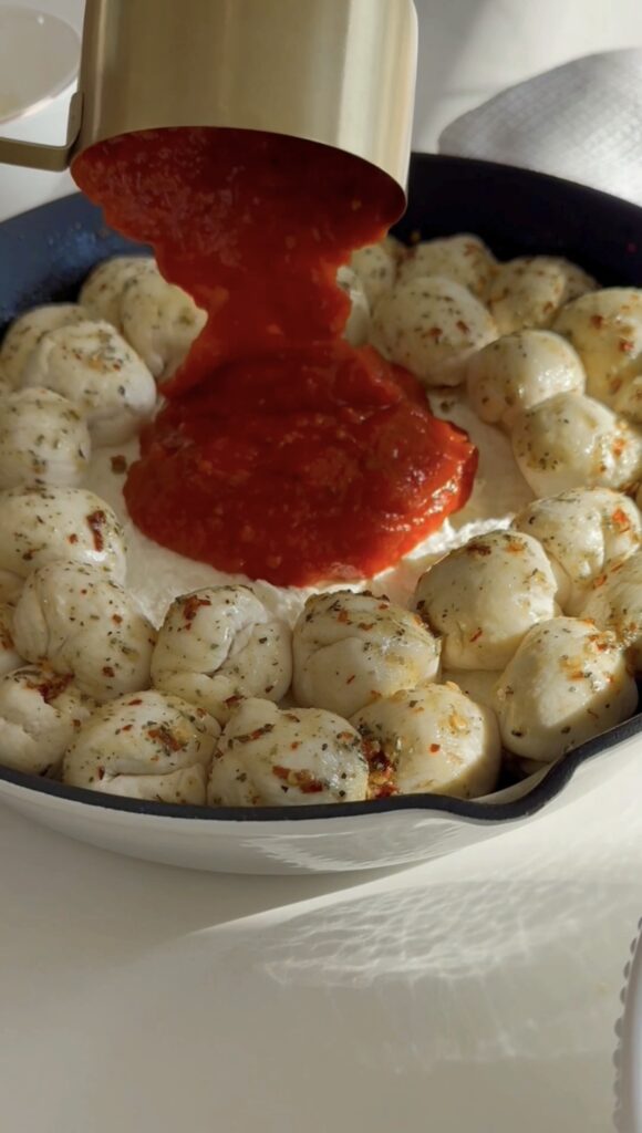 stir and gather pouring marinara into skillet for pizza dip
